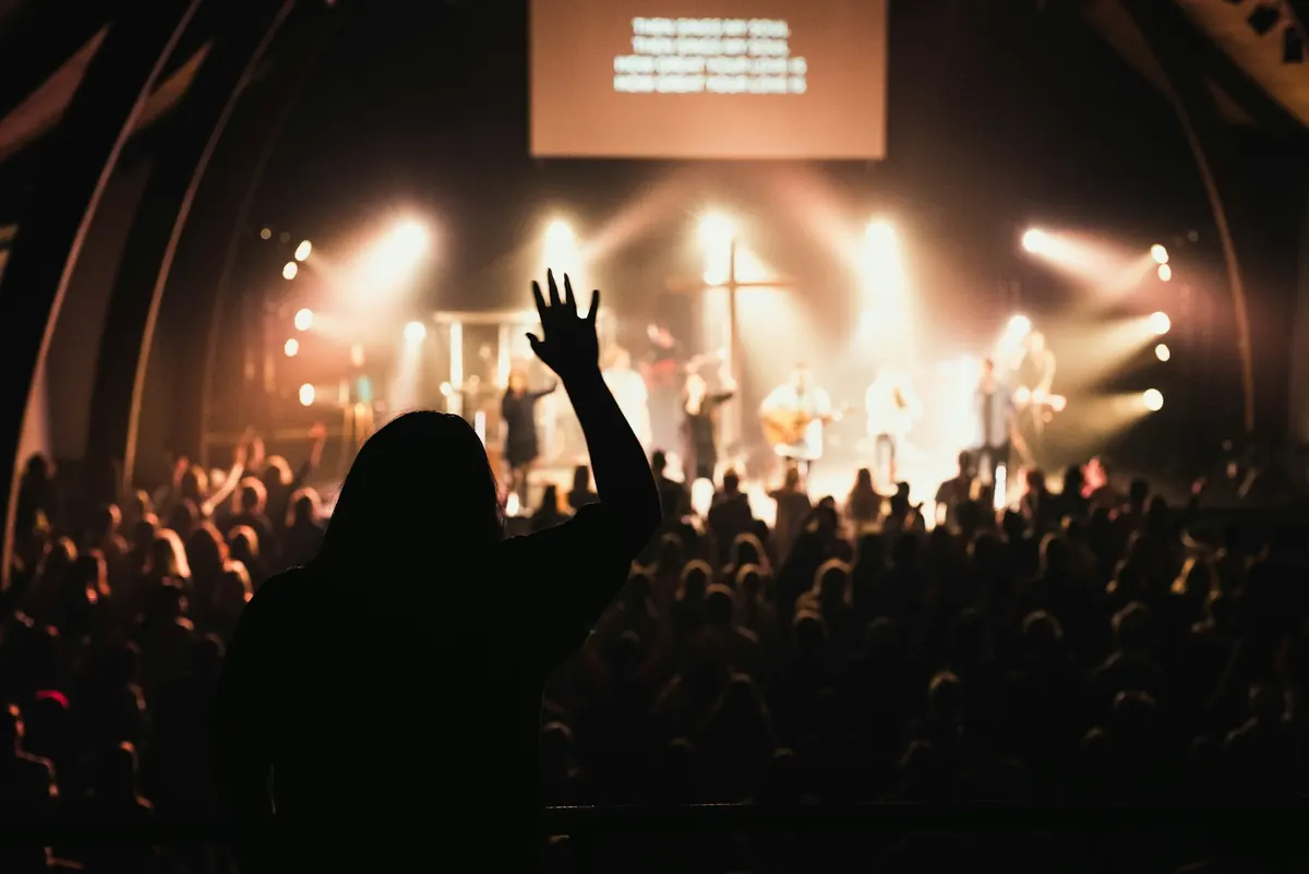 A packed worship night with hands raised toward the stage